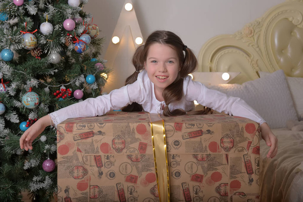 portrait of brunette girl with a huge gift at christmas - Foto, Bild