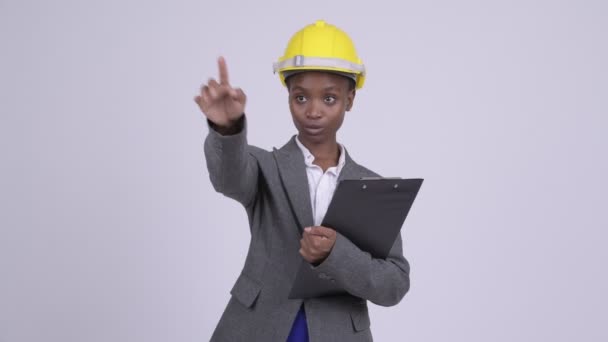 Young African businesswoman wearing hardhat directing with clipboard - Кадри, відео