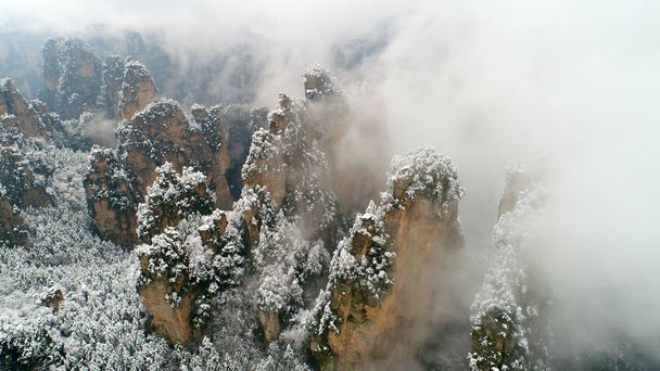 武陵源景観と 2017 年 2 月 23 日の中国中央部の湖北省張り家界市の歴史的な地区で雪に覆われた山の上の雲の海の空撮 - 写真・画像