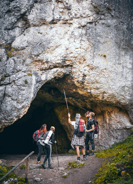 Gruppo di escursionisti alla scoperta della grotta in montagna
 - Foto, immagini