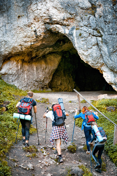 Group of hikers exploring cave in the mountain - 写真・画像