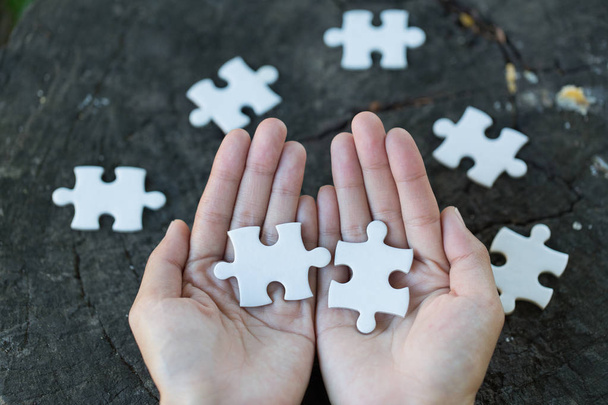 Jigsaw puzzle in the hand of a businessman,  Business team assembling Jigsaw puzzle. - 写真・画像