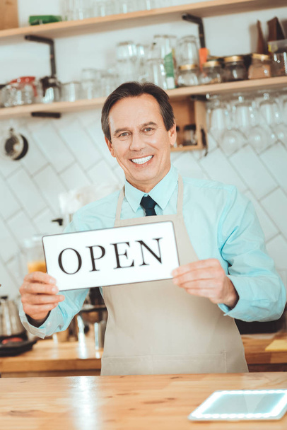 Cheerful owner opening his coffee shop - Fotografie, Obrázek