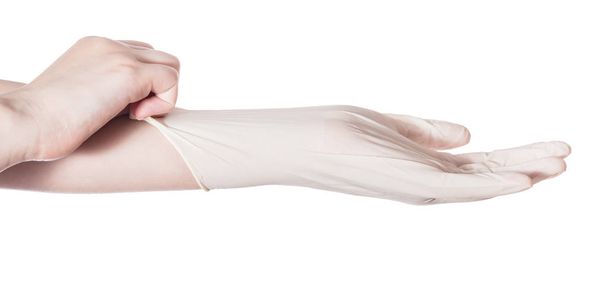 profiel te bekijken van vrouwelijke hand trekt latex handschoen aan de andere kant geïsoleerd op witte achtergrond - Foto, afbeelding