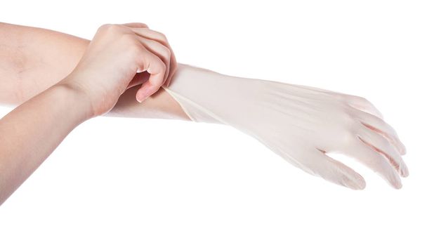por encima de la vista de la mano femenina tira del guante de látex en otra mano aislada sobre fondo blanco
 - Foto, Imagen