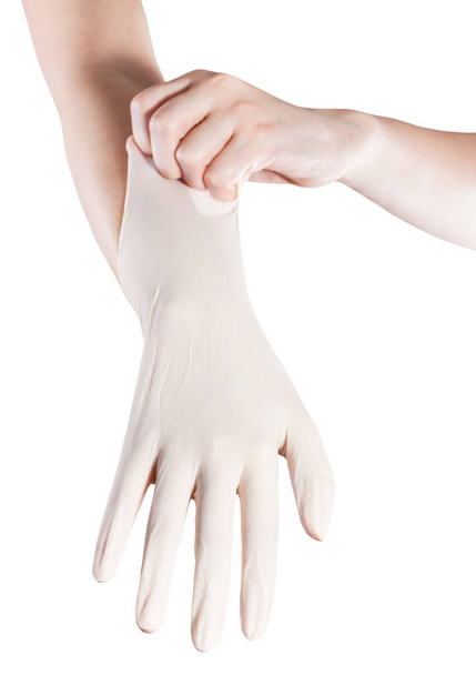 vista frontal de la mano femenina tira del guante de látex en otra mano aislada sobre fondo blanco
 - Foto, Imagen