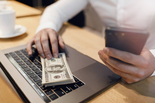 man with laptop and money on background. - Foto, Imagen
