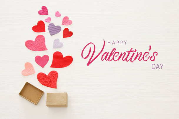 Valentine's day concept. Paper hearts over wooden white background. Flat lay - Фото, изображение