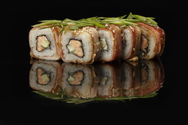 verschillende sushi, broodjes op een zwarte achtergrond met reflectie. vooral voor cafés en restaurants - Foto, afbeelding