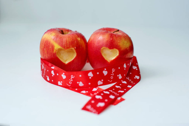 Liefde van appels concept met een netjes ingesneden hart in de huid van een rijpe rode appel in St. Valentina de dag - Foto, afbeelding