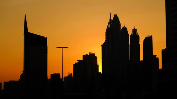 Siluetas de rascacielos al atardecer del día en Dubai
 - Metraje, vídeo