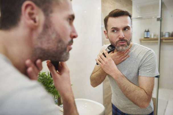 Man with electric razor shaving  - 写真・画像