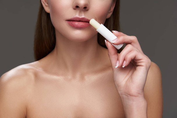 Young lady with beautiful lips using hygienic lipstick - Foto, immagini