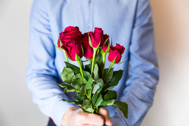 Valentines day surprise - man holding red rose in front of him, romantic relationship partner, love. - Foto, Imagen