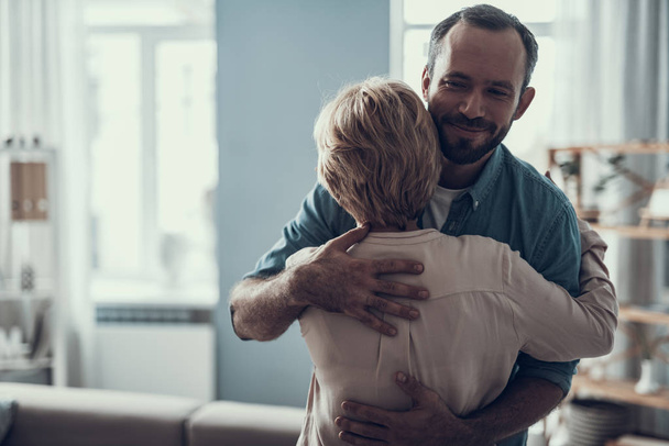 Happy bearded man smiling and kindly hugging woman - Foto, immagini