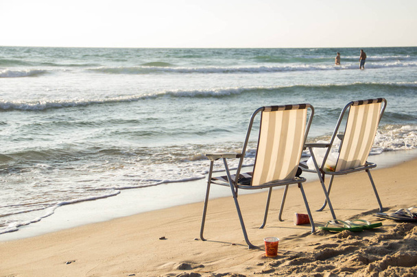 Due sedie si trovano sulla spiaggia vicino al mare
 - Foto, immagini