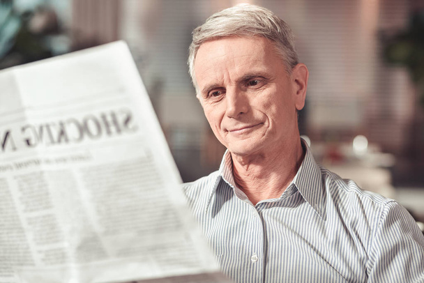 High-spirited pensioner reading an interesting article in a cafe - Fotoğraf, Görsel