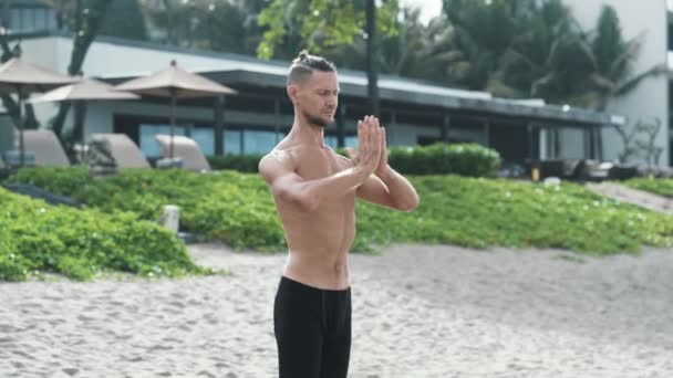 Sporty man doing yoga breathing exercises with his hands together and eyes closed. - Metraje, vídeo