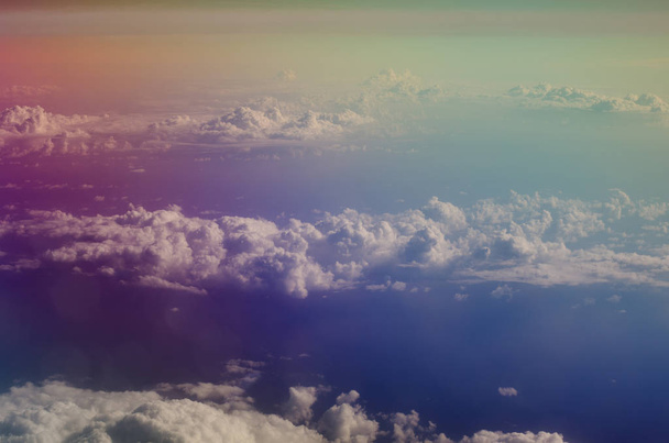 Вид ілюмінатора літака на пухнасті кумульські хмари та блакитне небо
. - Фото, зображення