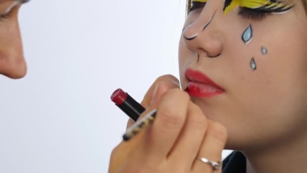 Makeup artist doing professional comic pop art make-up. Funny cartoon or comic strip make-up - Záběry, video