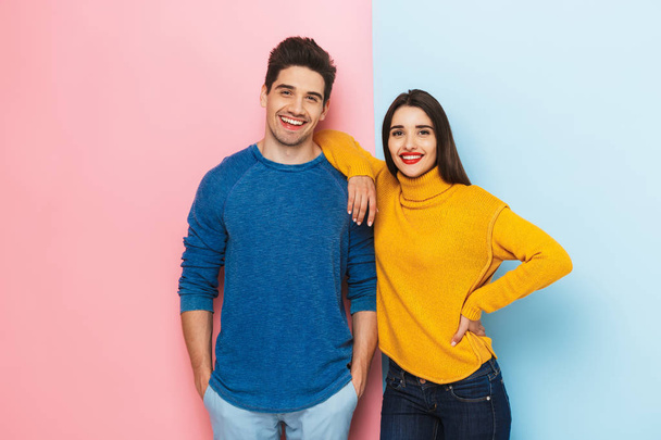 Alegre jovem casal de pé isolado sobre dois fundo colorido
 - Foto, Imagem