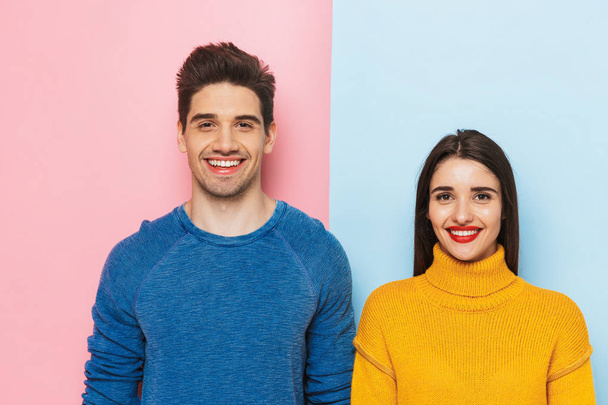 Cheerful young couple standing isolated over two colored background - Foto, immagini