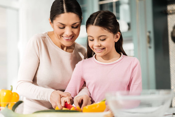 Positive delighted mom and kid that cooking together - Foto, Bild