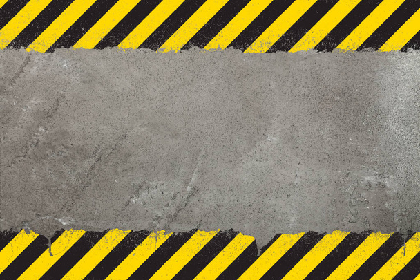 Concrete weathered wall background with yellow and black painted grunge hazard sign stripes and copy space - Photo, Image