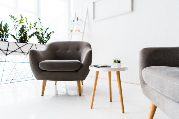 moderni sisustus valkoinen odotussali harmaa nojatuolit ja pöytä
 - Valokuva, kuva