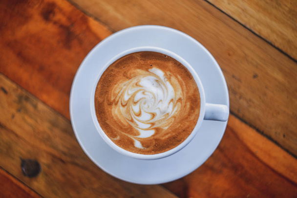 Kaffeetasse vorhanden. eine Tasse Kaffee in einer weißen Tasse auf hölzernem Hintergrund  - Foto, Bild