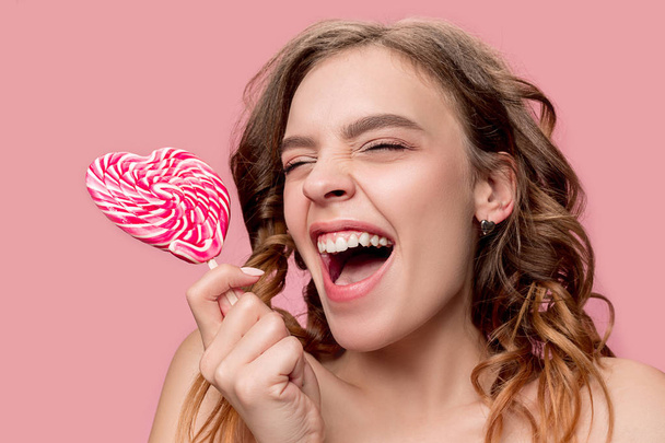 beauty portrait of a cute girl in act to eat a candy - Foto, immagini