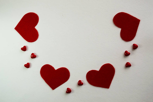 День святого Валентина фон с красными сердцами на белом столе, вид сверху. Красное сердце для валентинки
 - Фото, изображение