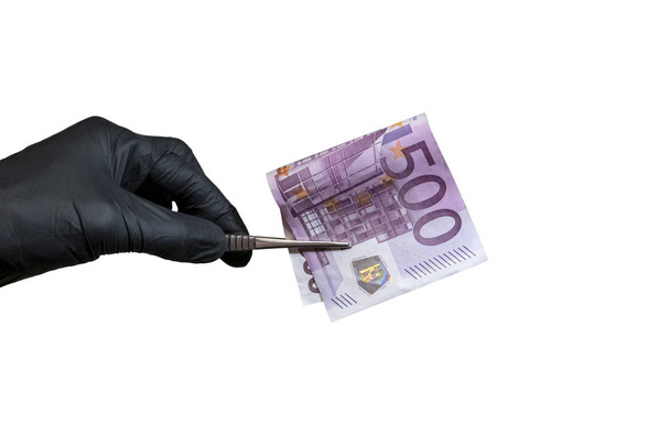 Detail. Ruka v černé gumové rukavici drží pinzeta s Billem pět set euro. Pojem korupce nebo kontrolu padělání peněz, laboratorních testů Forenzních služeb. Izolovat na bílém pozadí. - Fotografie, Obrázek