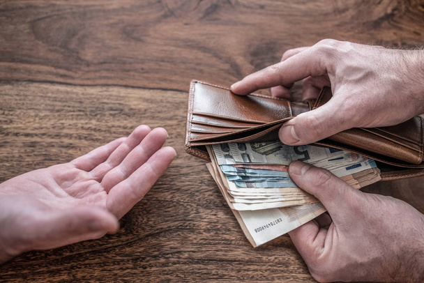 persons handing over money to one another - Valokuva, kuva