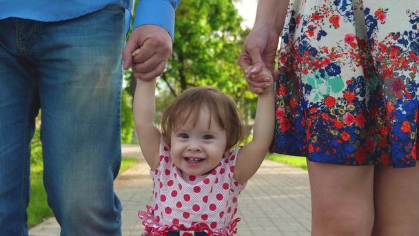 bebé aprendiendo a caminar con mamá y papá, familia feliz caminando en el parque de verano
 - Foto, Imagen