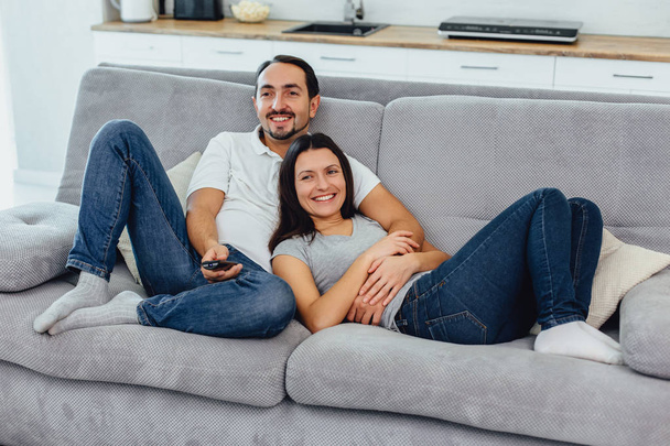 Husband and wife sitting on a sofa - Фото, зображення