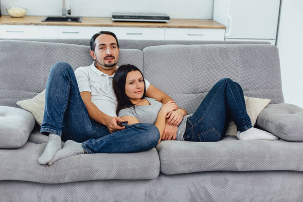 Husband and wife sitting on a sofa - Фото, зображення