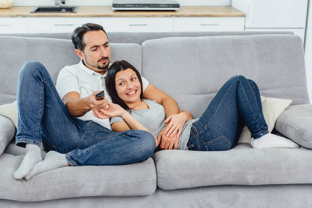 Husband and wife sitting on a sofa - Фото, изображение
