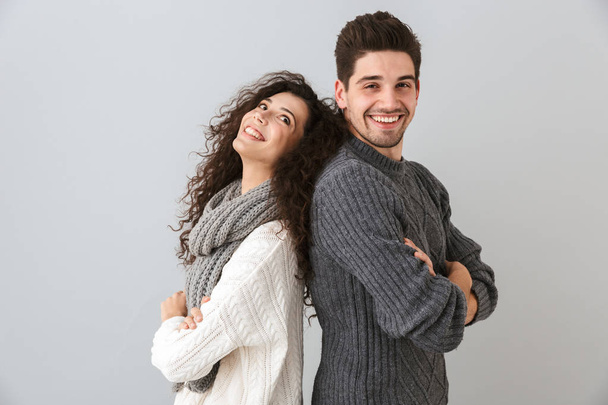 Portrait of european couple man and woman standing back to back with arms crossed isolated over gray background - Foto, imagen