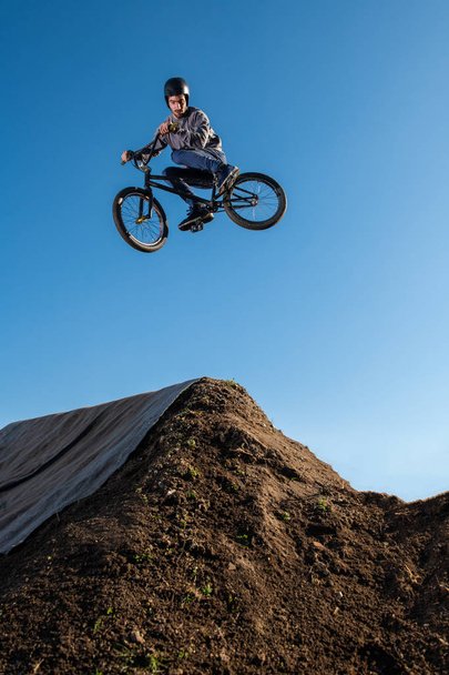 BMX Bike jump over a dirt trail on a dirt track. - Fotografie, Obrázek
