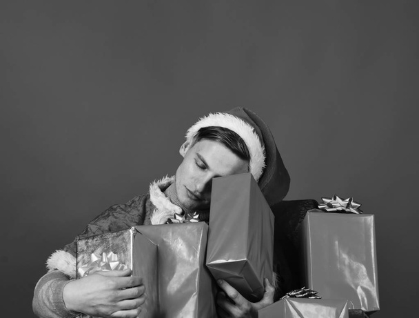 Man holds xmas presents. Santa with relaxed face with gifts - Foto, Imagen