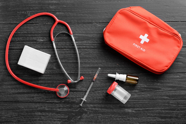 Stethoscope, drugs and first aid kit on wooden background. Health care concept - Φωτογραφία, εικόνα
