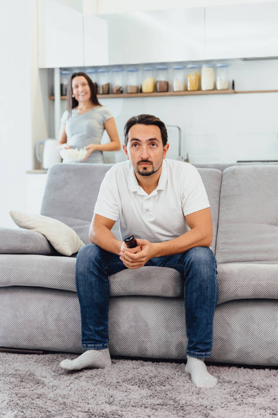 A man watches TV, while his wife looks at him - Фото, зображення