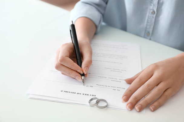 Νεαρή γυναίκα υπογραφή διαζυγίου στο τραπέζι, κοντινό πλάνο - Φωτογραφία, εικόνα