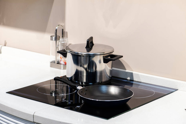 Чорна скляна індукційна панель на кухні
 - Фото, зображення