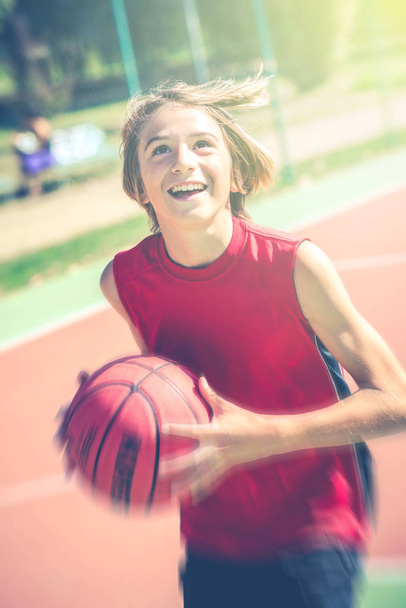 happy teenager play basketball outdoor - healthy sporty teenagers lifestyle concept in spring or summer time - Foto, Imagen