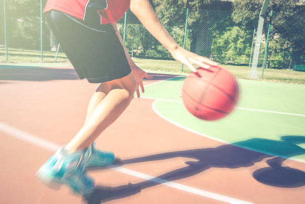 teenager play basketball outdoor - healthy sporty teenagers lifestyle concept in spring or summer time - Foto, Imagen