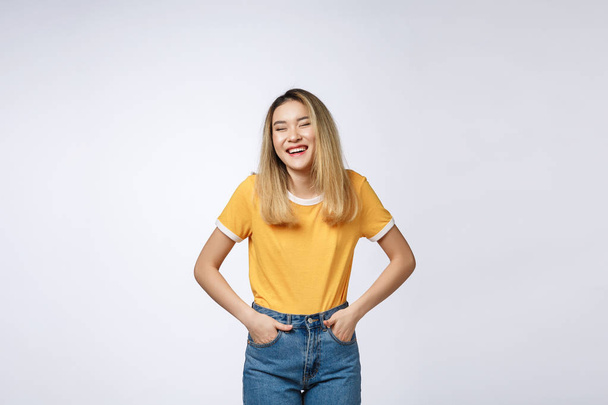 Jonge vriendelijke Aziatische vrouw met smiley gezicht geïsoleerd op witte achtergrond. - Foto, afbeelding