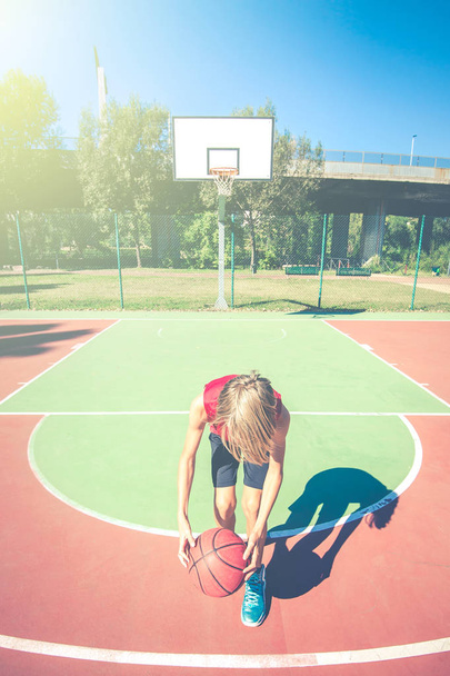 happy teenager play basketball outdoor - healthy sporty teenagers lifestyle concept in spring or summer time - Foto, immagini