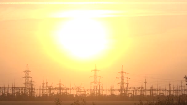 Wysokie napięcie zasilania stacji o zachodzie słońca - Materiał filmowy, wideo
